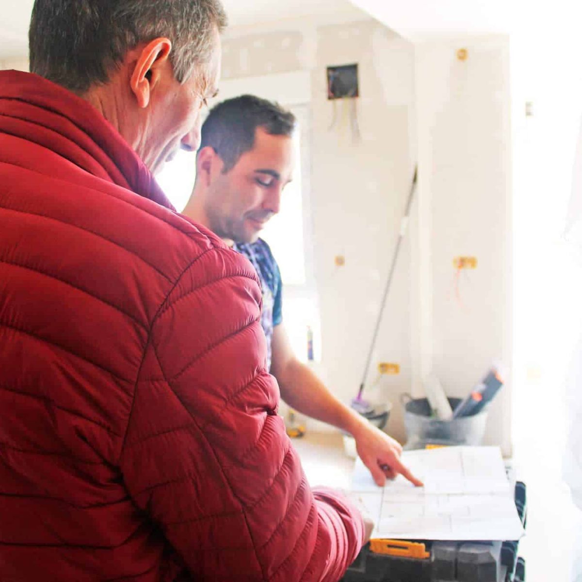 Dos hombres revisando planos en una construcción.