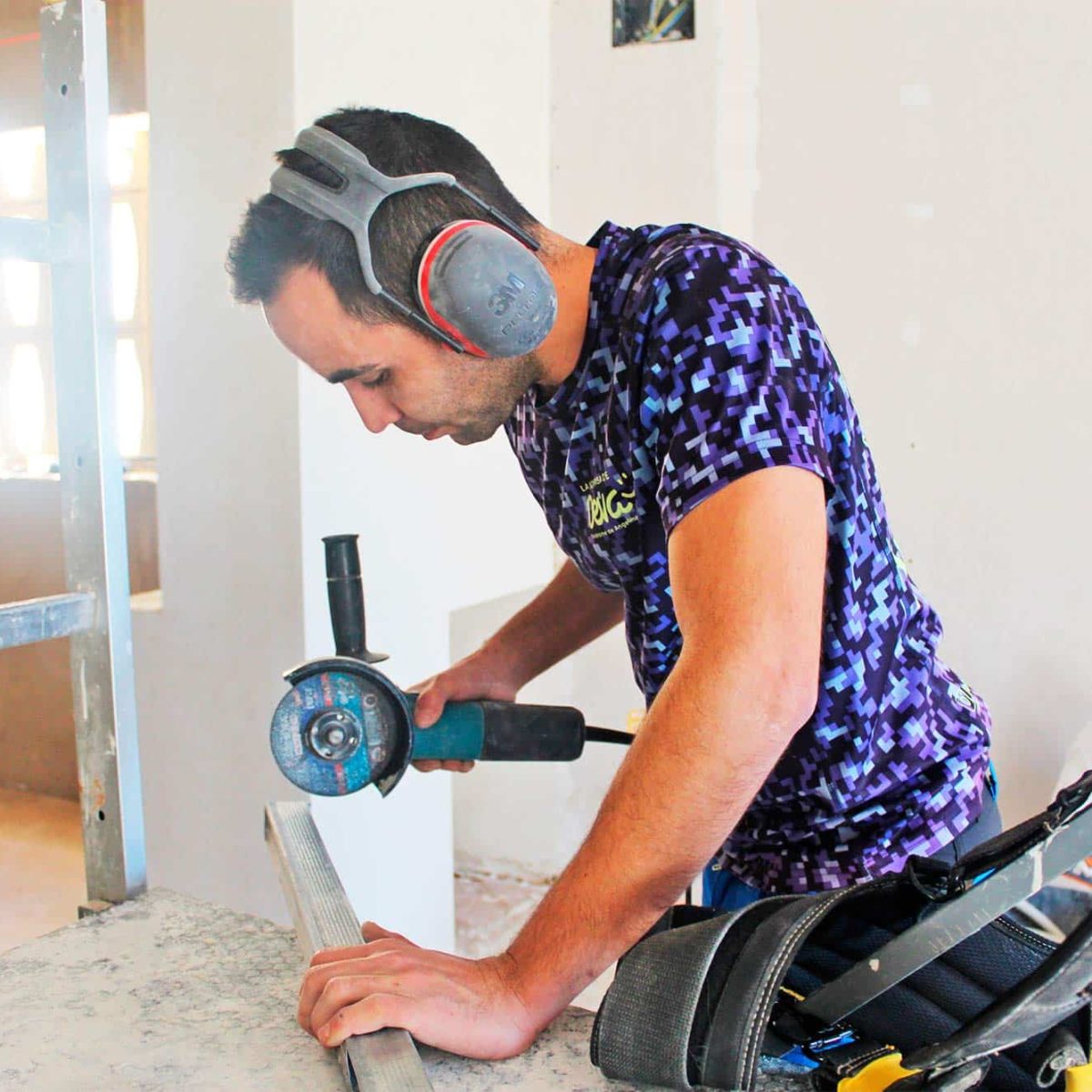 Hombre usando una herramienta en un entorno de construcción.