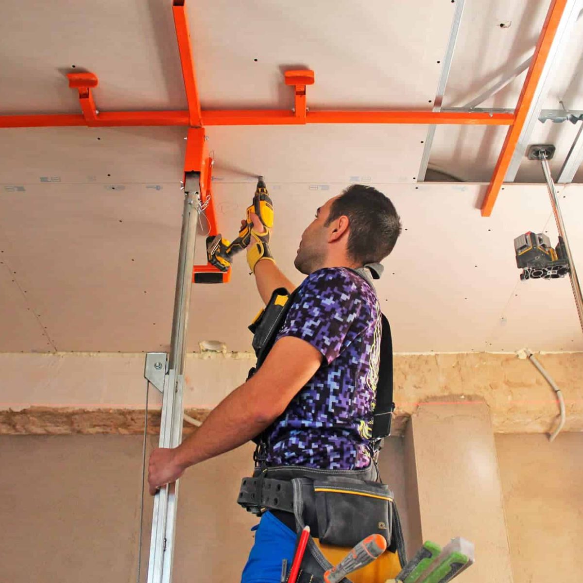 Hombre instalando un techo con herramientas en la mano.